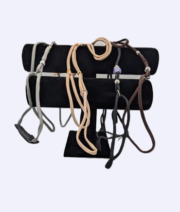 Leather cord necklaces displayed on a black velvet stand.