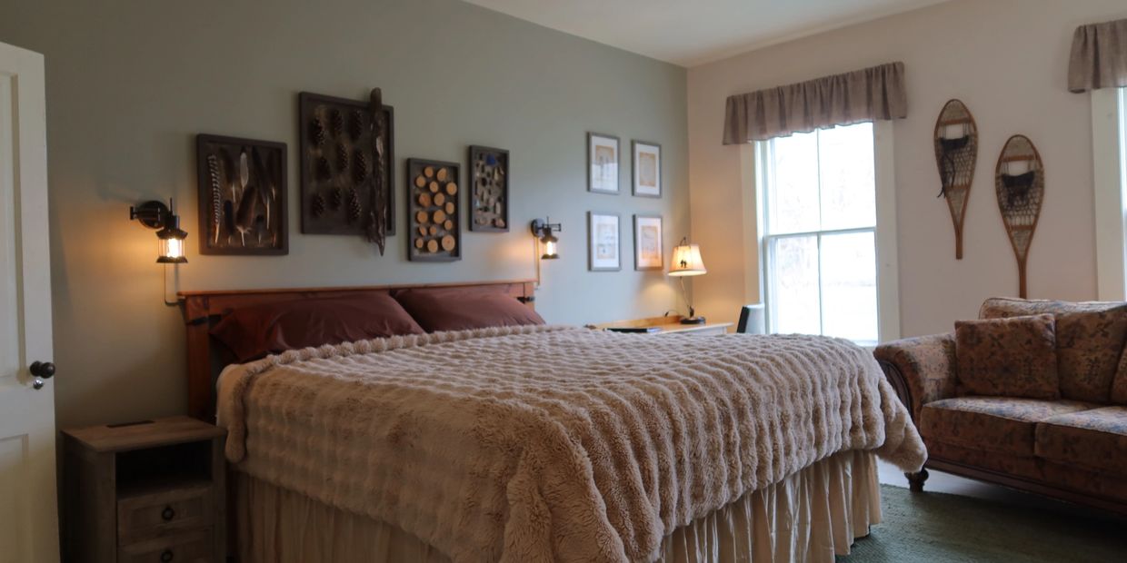 Cozy bedroom with a large bed, rustic decor, and warm lighting.
