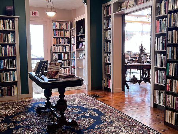 Cozy library room with bookshelves and vintage table.
