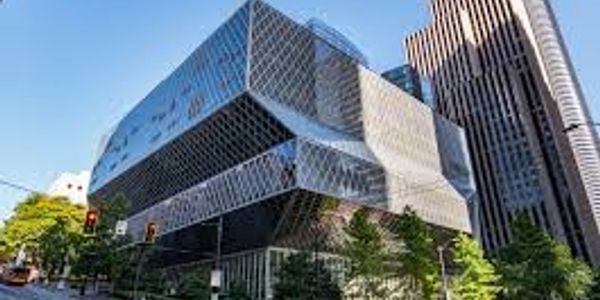 Modern geometric glass building in urban setting.