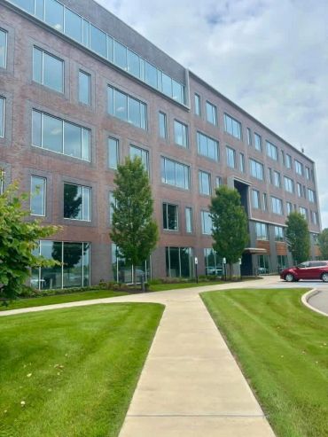 Office building with green lawn and pathways.