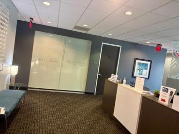 A modern office reception area with seating and a front desk.