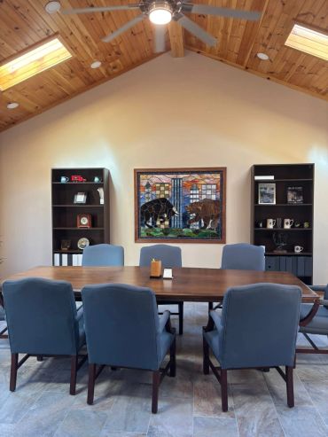 Modern conference room with a wooden table and blue chairs.