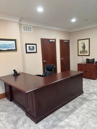 A tidy office with a wooden desk and chair.
