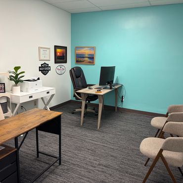 Neat office space with turquoise accent wall and seating area.
