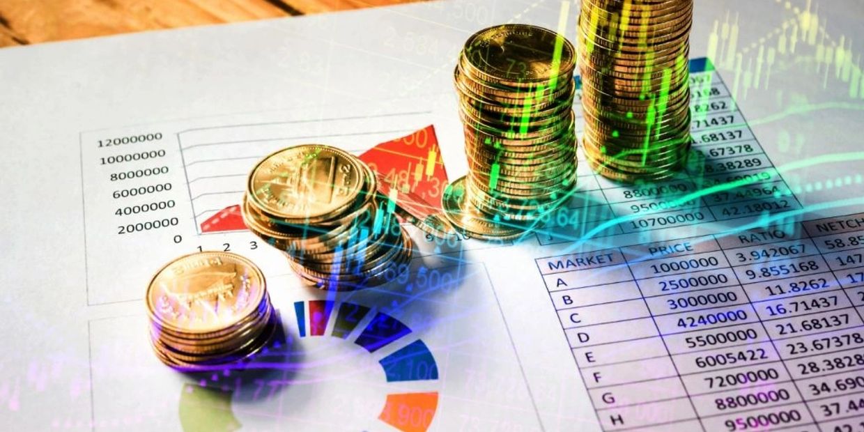 Stacks of coins on financial charts and tables.