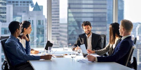 Business meeting with five professionals in a modern office.