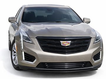 Front view of a sleek silver Cadillac SUV with a prominent grille and stylish headlights.