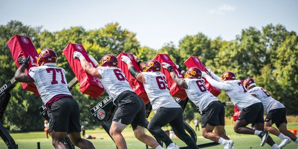 A serene landscape featuring rolling hills, a clear blue sky, and a peaceful river flowing through the greenery.
