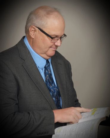 Man in suit reading a book.