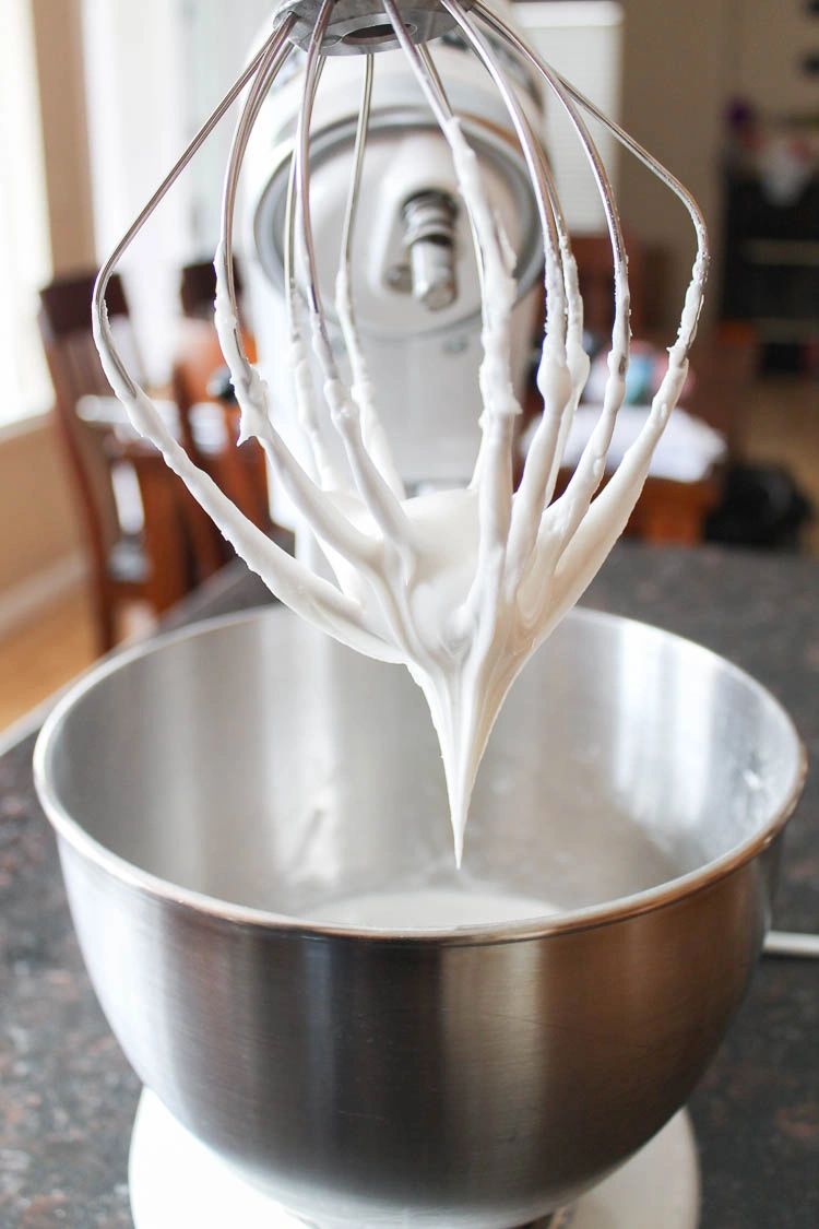 Mixer with whisk attachment dipped in royal icing.