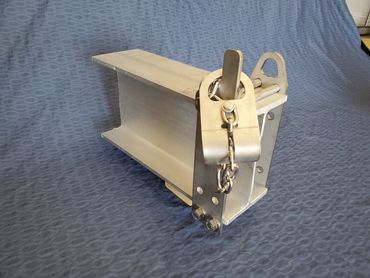 Metal industrial component with chain and latch on a blue background.
