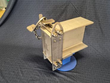 A wooden mechanical model with metal parts and a blue base.