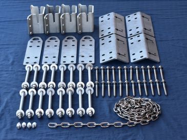 Metal hardware parts including brackets, bolts, and chains arranged on blue fabric.