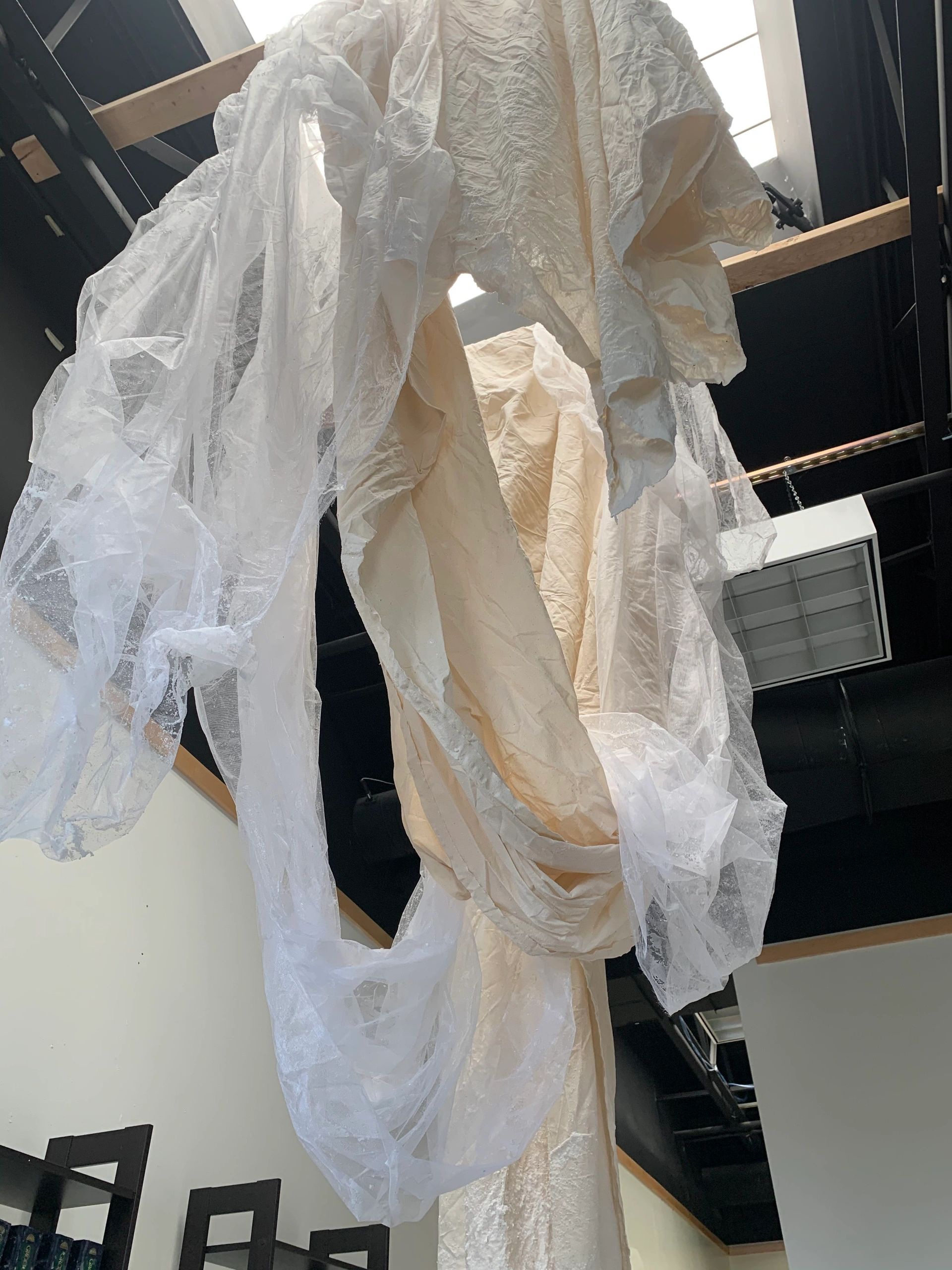 Several yards of off-white fabric is draped from the ceiling.