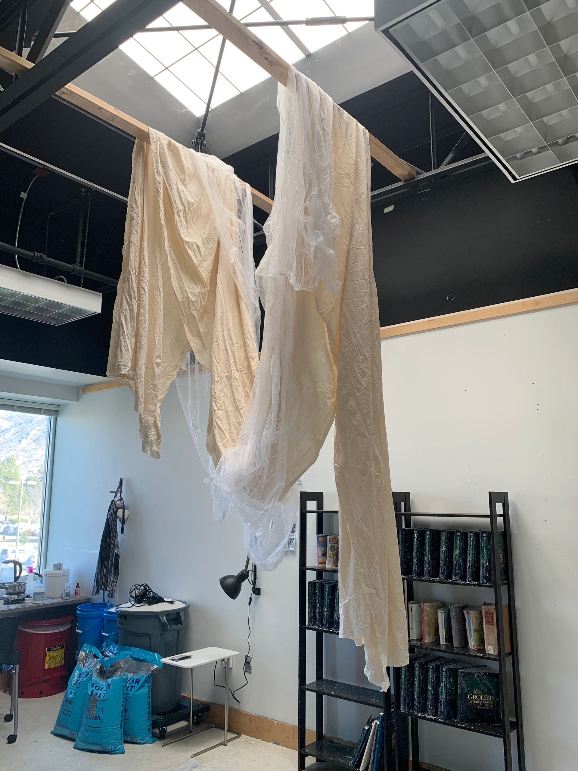 Several yards of off-white fabric is draped from the ceiling.