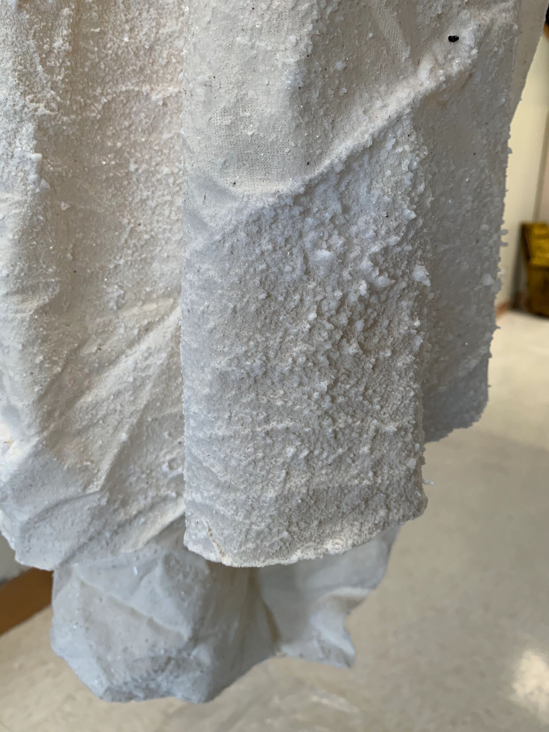 White salt crystals growing on fabric.