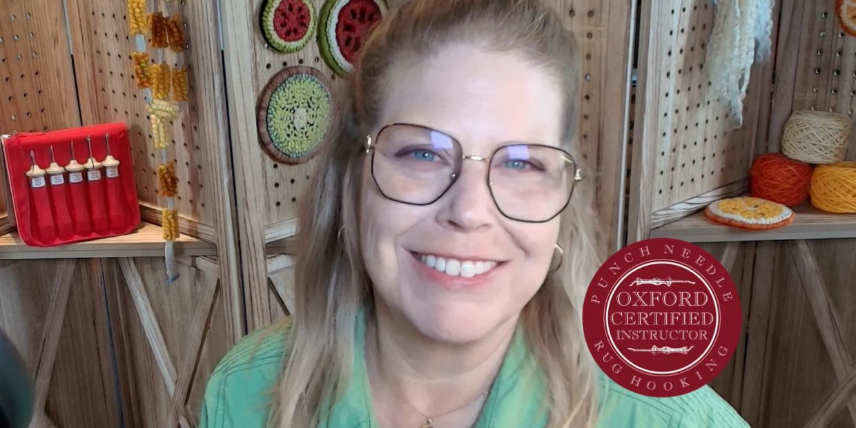 Smiling woman with glasses in a cozy craft room.