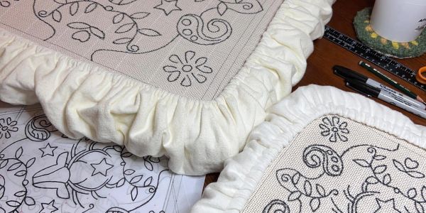 Embroidery project with floral and star designs.