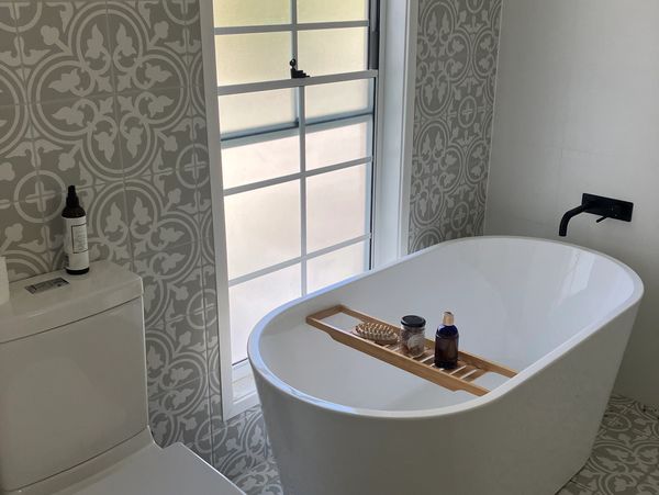Modern bathroom with a freestanding bathtub and patterned tiles. Works done by McKee Brothers.
