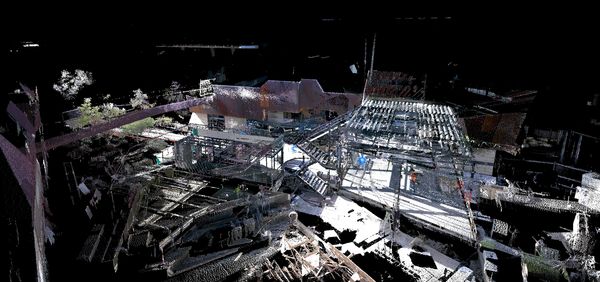 3D point cloud scan of a construction site with structural framework and workers.
