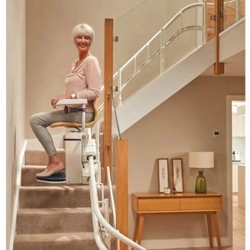 Senior woman using a stairlift in her home.