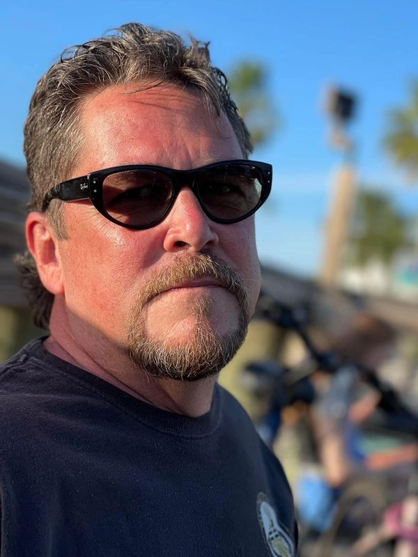 Man wearing sunglasses outdoors on a sunny day.