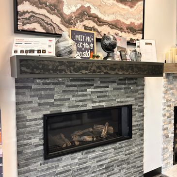 Modern gray stone fireplace with decorative items and abstract wall art.