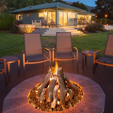 Cozy backyard fire pit with chairs at dusk.