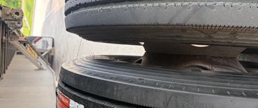 Close-up of two worn truck tires side by side on a trailer.