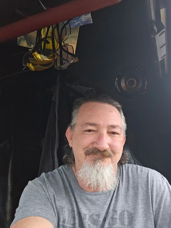 Man with a gray beard smiling.