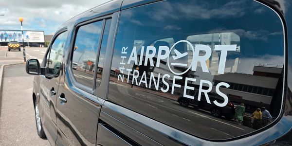 Black van offering 24-hour airport transfer services.