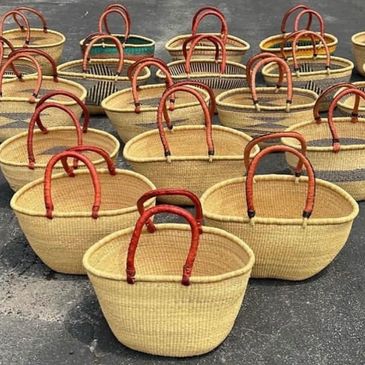 Woven baskets with red handles arranged outdoors.