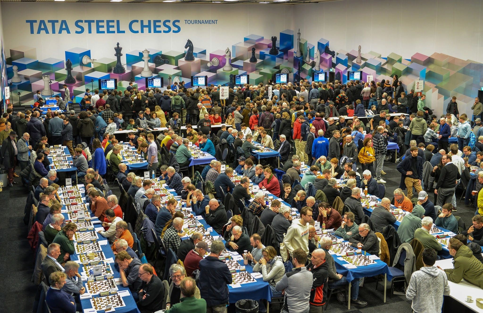 Magnus Carlsen at Tata Steel Chess 2019, Anish Giri walking…