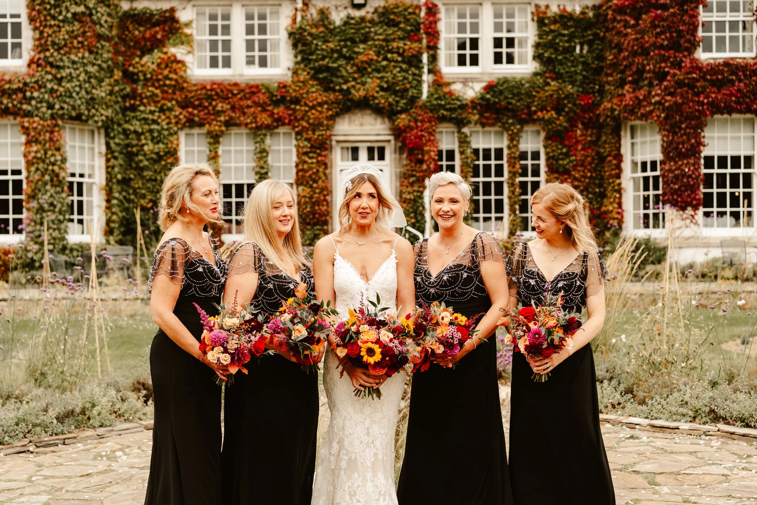 Bridesmaids wearing black dresses standing outside The Rufflets hotel St Andrews