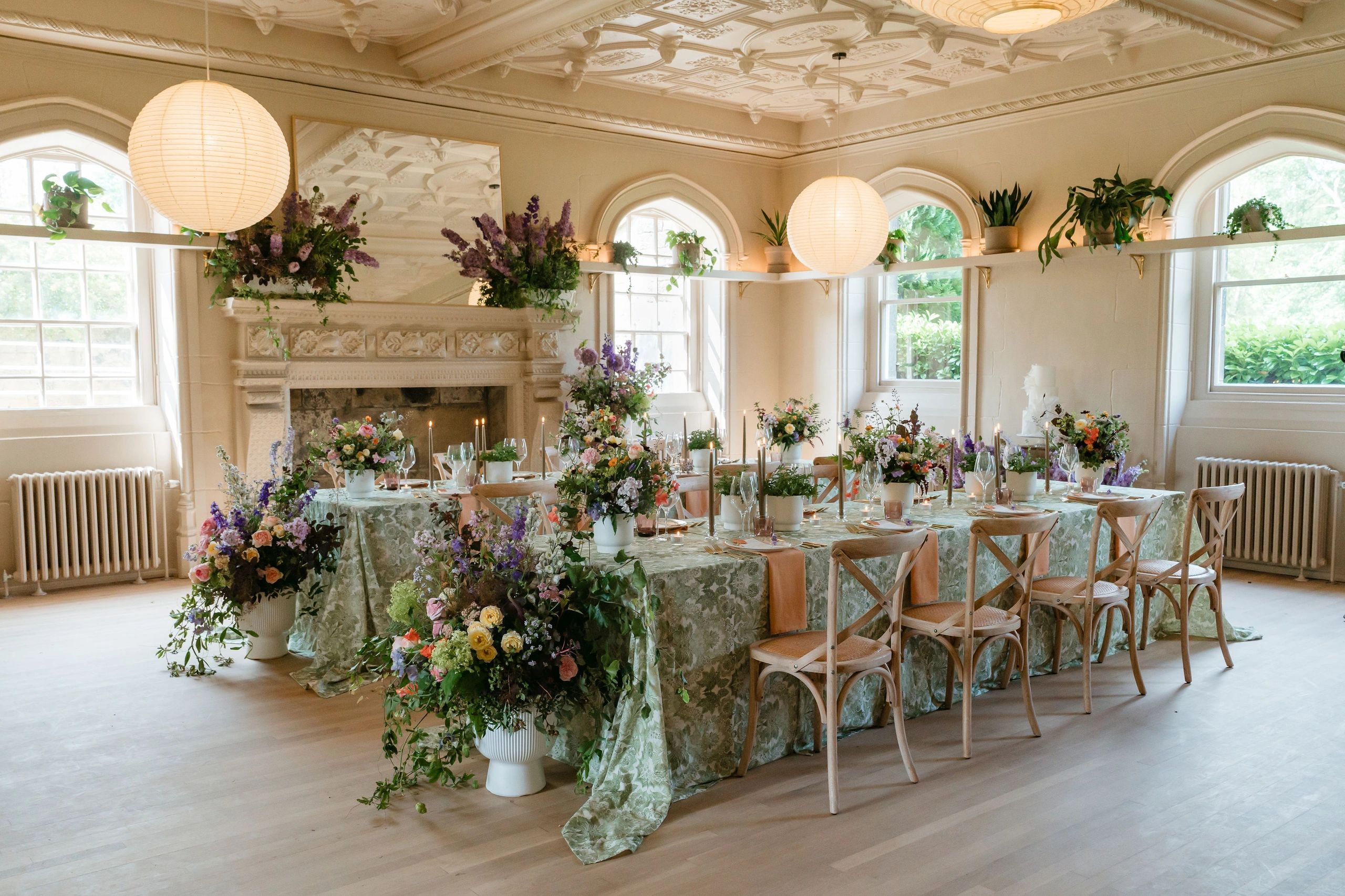 Wedding table breakfast room, room set up with large floral displays, long tables with centrepieces 