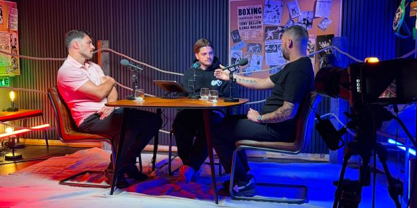Three men recording a podcast in a colorful studio.
