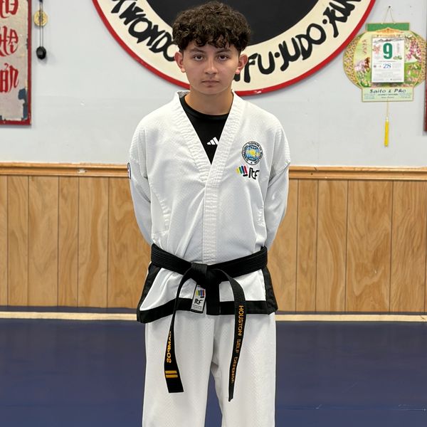 Teen in taekwondo uniform with black belt.