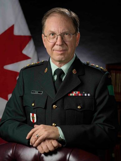 Portrait of a Canadian military officer in uniform with a Canadian flag background.