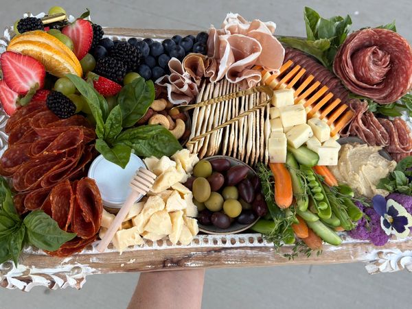 This 4-6 person board features four types of specialty meats and cheeses, nuts, olives, hummus, arti