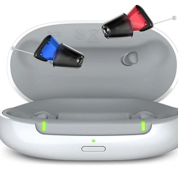 Wireless earbuds with red and blue tips in a charging case.