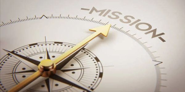 Close-up of a compass pointing to the word 'MISSION'.