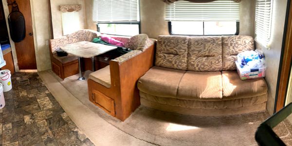 Interior of a cozy RV with seating and dining area.