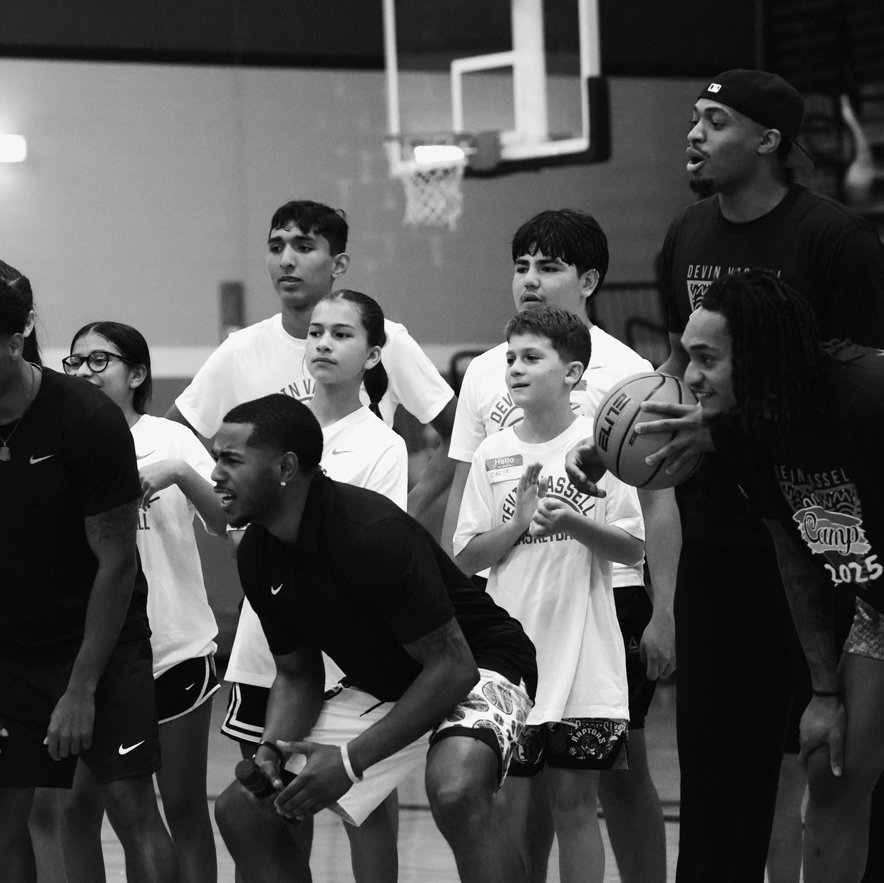 Youth basketball camp with coaches and kids preparing for a game.