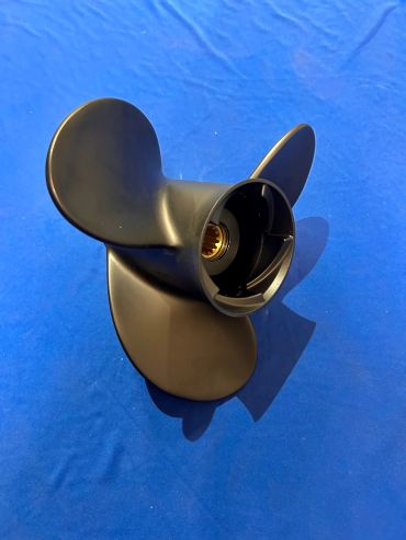 Black three-blade boat propeller on blue surface.