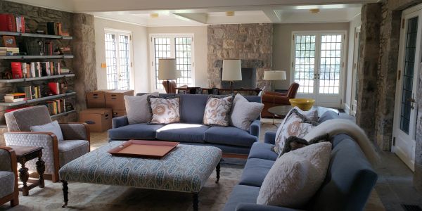 Cozy living room with blue sofas and stone walls.