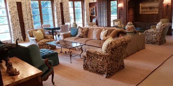Elegant living room with floral armchairs and large windows.