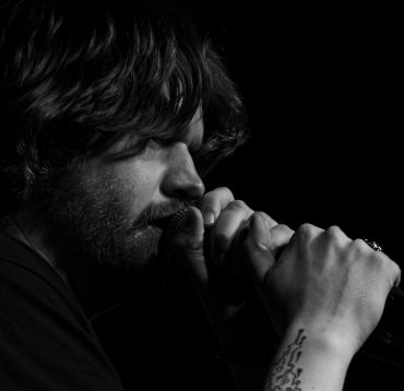 Black and white portrait of a man singing.