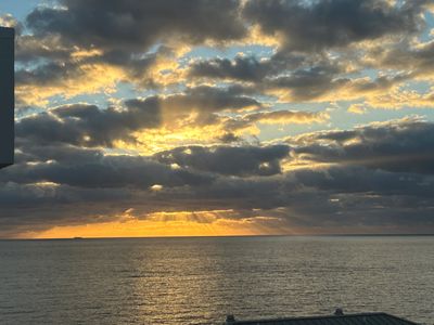 Sunset peeking through clouds over the ocean