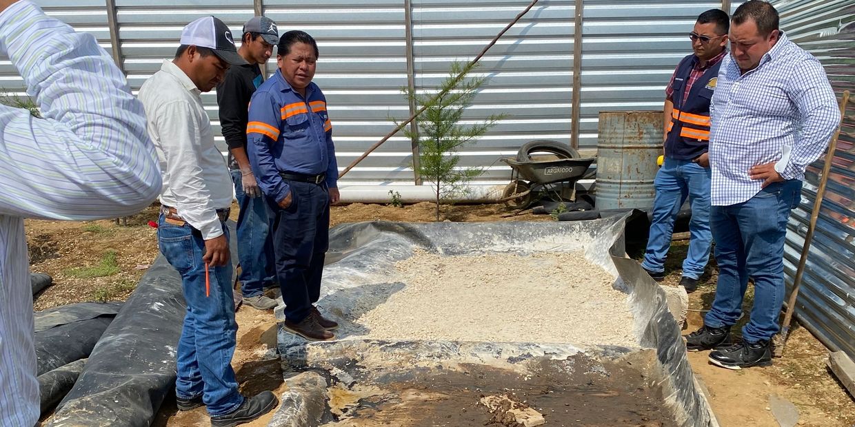 Group of men inspecting a construction site with cement and plastic sheeting.